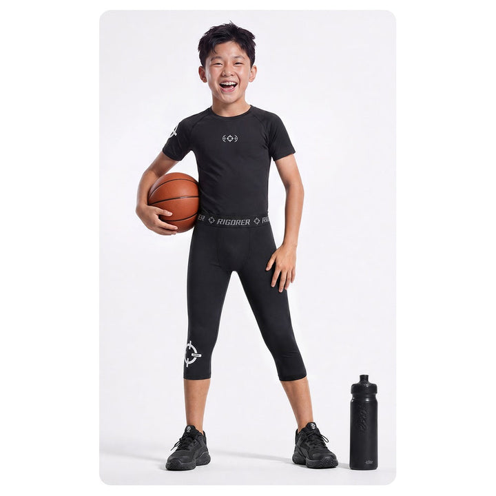 Rigorer kids compression shirt in black, worn with a basketball